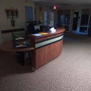 A dimly lit office reception area with a wooden desk.