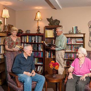 A group of seniors enjoying time together in a cozy library setting.