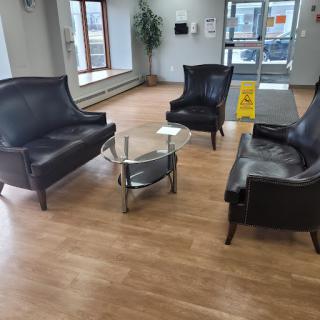 A cozy waiting area featuring leather seating and a central coffee table.
