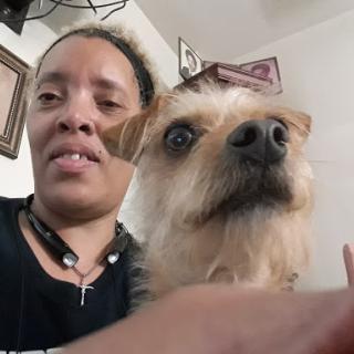 A person taking a selfie with their dog, both looking at the camera.