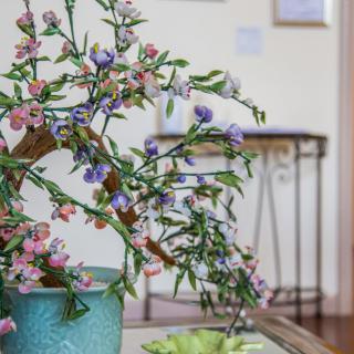 A decorative arrangement of colorful artificial flowers in a ceramic pot indoors.