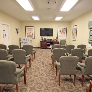 A conference room arranged with chairs facing a television, ready for a presentation.