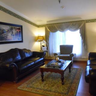 A cozy and well-furnished living room featuring black leather sofas, an armchair, and a stylish coffee table.