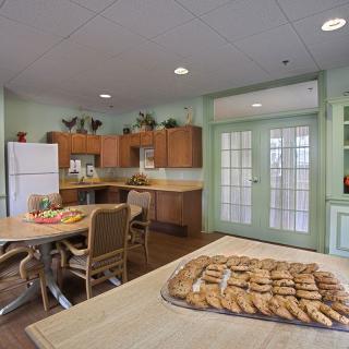 A cozy kitchen setup with cookies on the table and wooden cabinets.