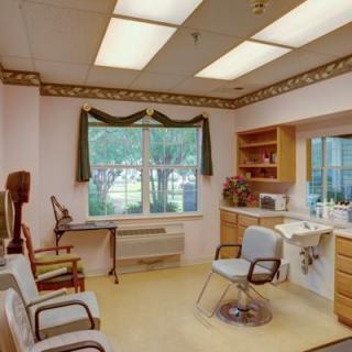 A bright and organized waiting room with chairs and a window letting in daylight.