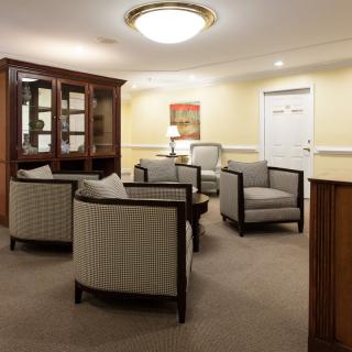 A cozy lobby or waiting area with armchairs and a cabinet.