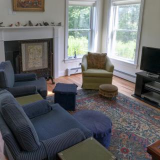 A cozy living room with comfortable seating, a fireplace, and a television.