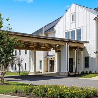 A modern building with a large entrance and well-maintained landscaping.