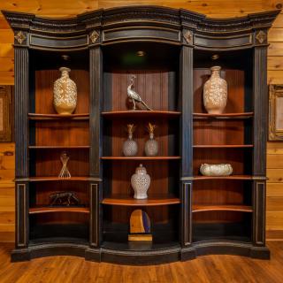 An elegant black and wooden bookshelf with decorative vases and artifacts.
