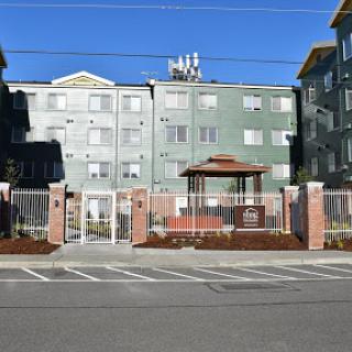 A view of a modern apartment complex featuring a gated entrance and an outdoor gazebo.