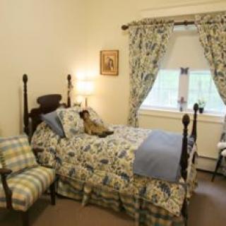 A cozy traditional bedroom with floral bedding and matching curtains.