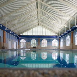 A serene indoor swimming pool reflecting the architectural beauty of its surroundings.