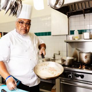 A chef cooking in a professional kitchen.