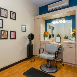 A cozy salon interior with a styling chair and mirror setup.