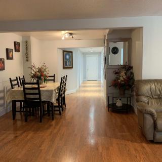 Spacious open-plan dining and living area with wooden flooring and cozy furnishings.