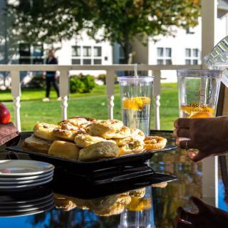 A delightful outdoor setting featuring a plate of pastries and refreshing drinks, perfect for a summer afternoon.