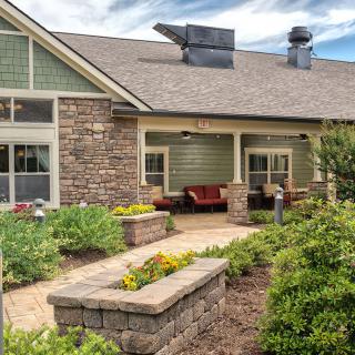 A charming countryside house with a spacious porch and well-maintained garden.
