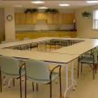 A conference room with U-shaped table arrangement and chairs.