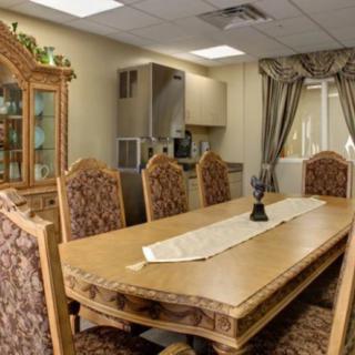 A classic dining room with ornate chairs and a wooden table adorned with a table runner.