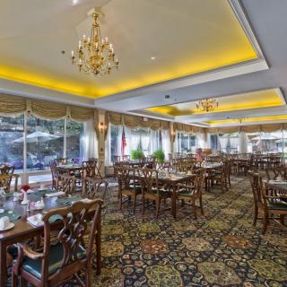 An elegant restaurant dining room with chandeliers and neatly arranged tables and chairs.