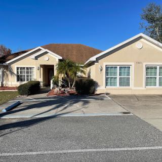 A beautiful residential house with a well-maintained front yard and clear blue skies.