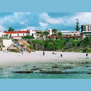A picturesque beach scene with people enjoying the sun and gentle waves.