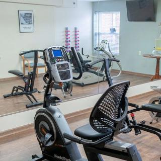 A small gym with exercise equipment including stationary bikes and a treadmill.