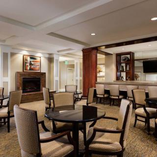 A cozy lounge area featuring comfortable seating, a fireplace, and a television.