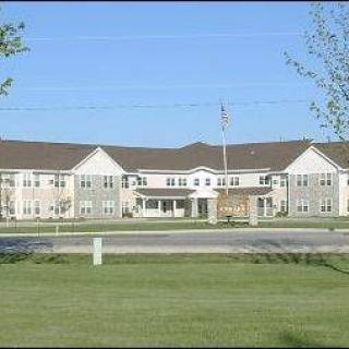 A suburban residential building with a well-maintained lawn and a clear blue sky.