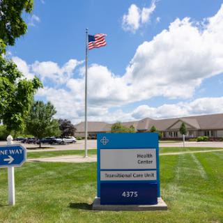 A sign indicating a location with an American flag flying in the background.
