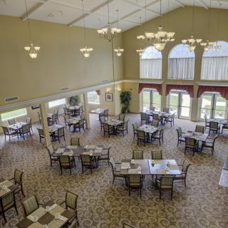 Spacious dining hall with elegantly arranged tables and large windows.