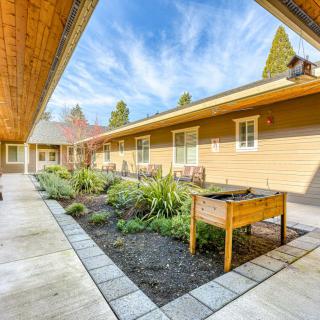 A peaceful courtyard with raised garden beds and well-maintained landscaping on a sunny day.