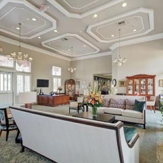 A spacious and elegantly designed living room with modern furniture and decorative ceiling lights.