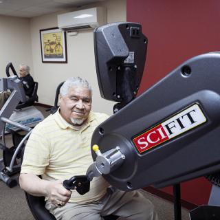 An elderly person using exercise equipment in a fitness room.