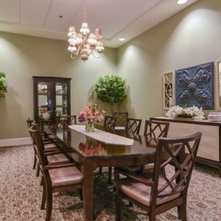 A well-decorated dining room with a long table, chairs, and a chandelier.