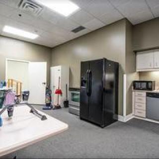 A small office kitchen with a refrigerator, microwave, and cabinets.
