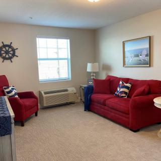 A cozy living room with nautical-themed decor and red furniture.
