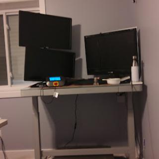 A modern home office setup featuring multiple monitors on a sleek desk.