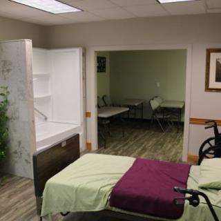 A hospital room featuring a patient bed, wheelchair, and an adjacent bathroom.