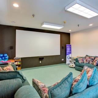 A cozy home theater with comfortable seating and a large projector screen.
