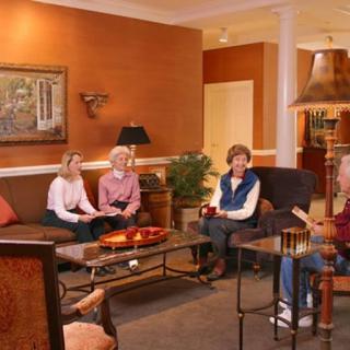 A group of people sitting in a cozy living room, engaged in conversation.