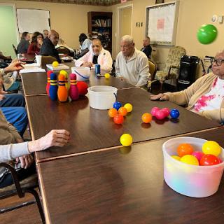 Seniors engaging in a recreational activity with colorful balls at a community center.