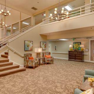Spacious lobby with a grand staircase and elegant decor.