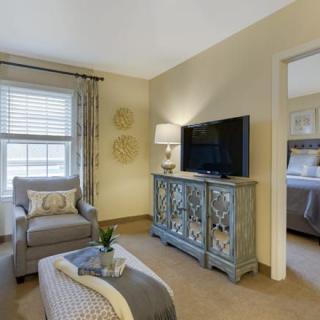 A cozy living room with an armchair, TV stand, and decorative elements.