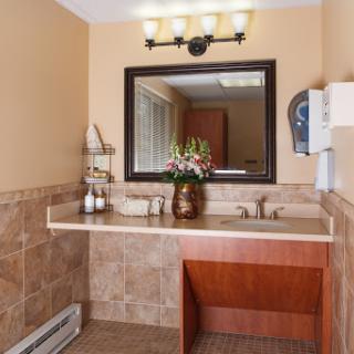A well-appointed bathroom featuring a stylish vanity, modern sink, and decorative flowers.