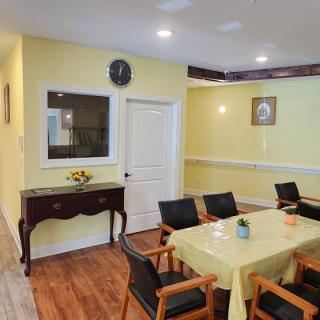 A cozy dining area with yellow walls and a wooden floor.