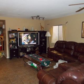A cozy living room featuring a television, leather couches, and a coffee table.