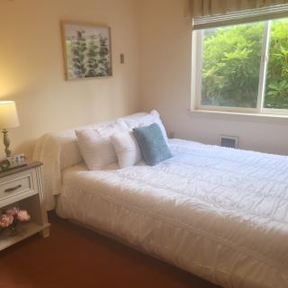 A cozy bedroom with natural light and simple decor.