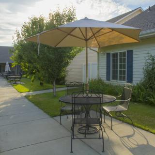 A cozy backyard patio with metal furniture and a large umbrella.