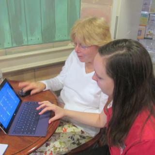 Two people working together on a laptop.